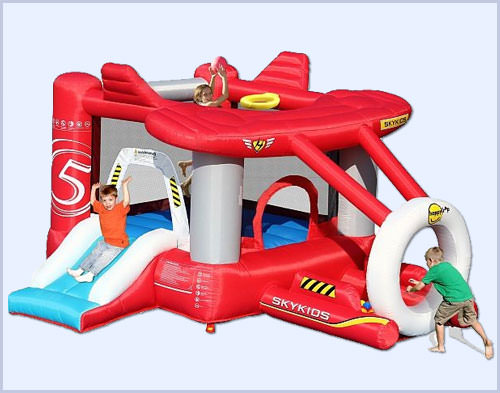 Ansicht der roten Hüpfburg in Form eines Flugzeugs mit spielenden Kindern.